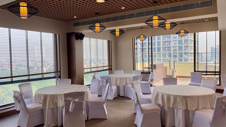 An image of a banquet hall with its seating arrangement and subtle decoration with lighting - Hideaway banquets & Lawns, Greater Noida