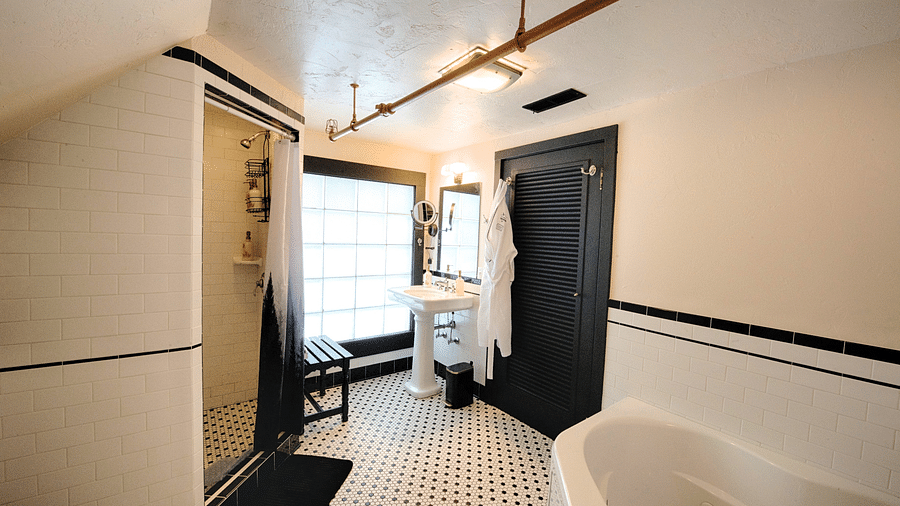 a bathroom featuring a jetted tub along with a huge window in the far corner - Historic Tapoco Lodge
