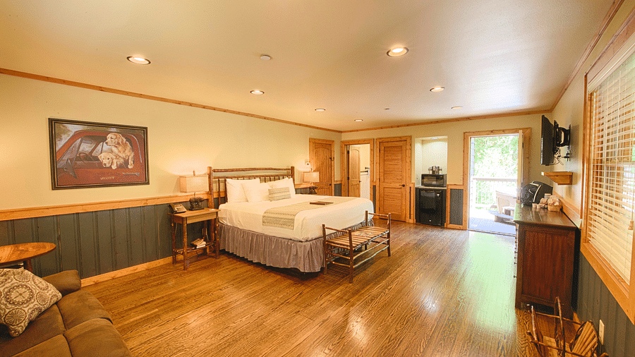an expansive room featuring a beautiful painting hung on the wall besides a plush double bed - Historic Tapoco Lodge