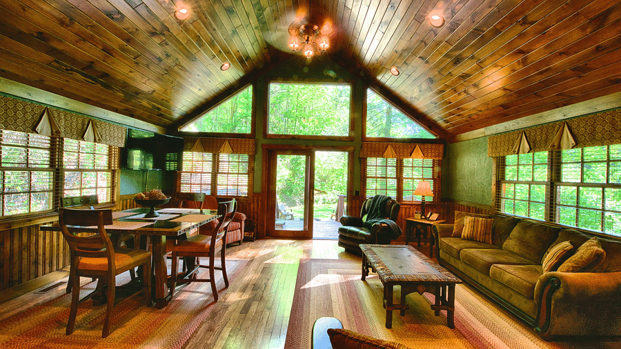 a living room with ample seating area featuring huge windows with wooden flooring and ceiling - Historic Tapoco Lodge