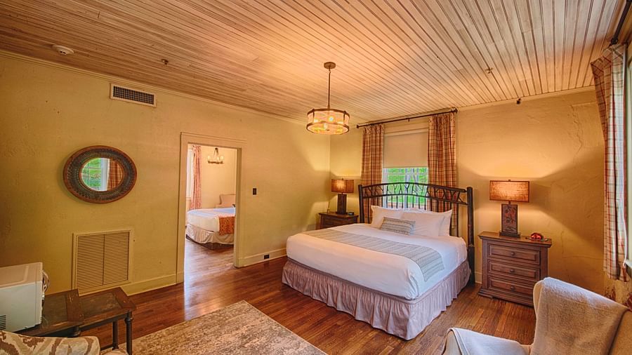 full view image of the evergreen suite featuring a double bed and a small window behind it - Historic Tapoco Lodge