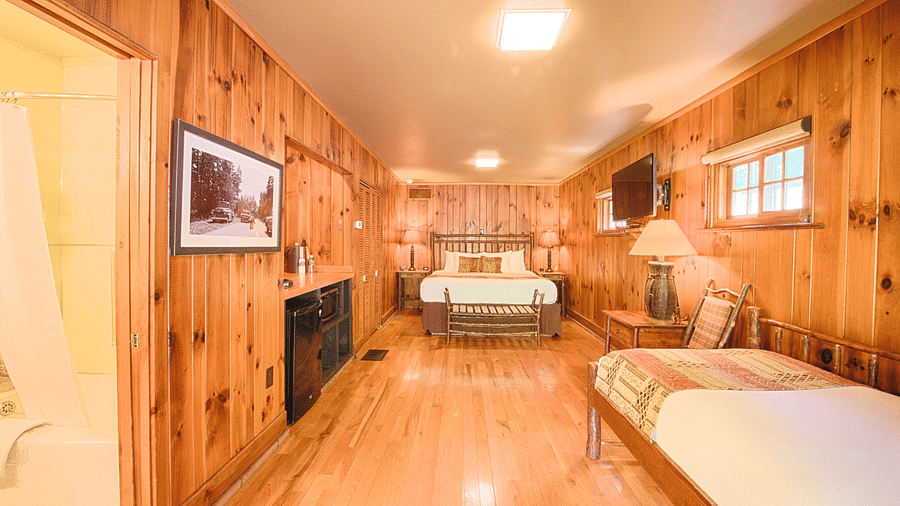 full view image of a bedroom with wooden interiors featuring two beds - Historic Tapoco Lodge