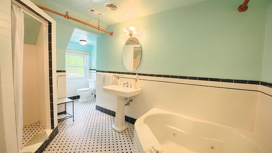 a chic and modern bathroom at the laurel suite featuring a big bath tub along with a shower cubical and a wash basin - Historic Tapoco Lodge