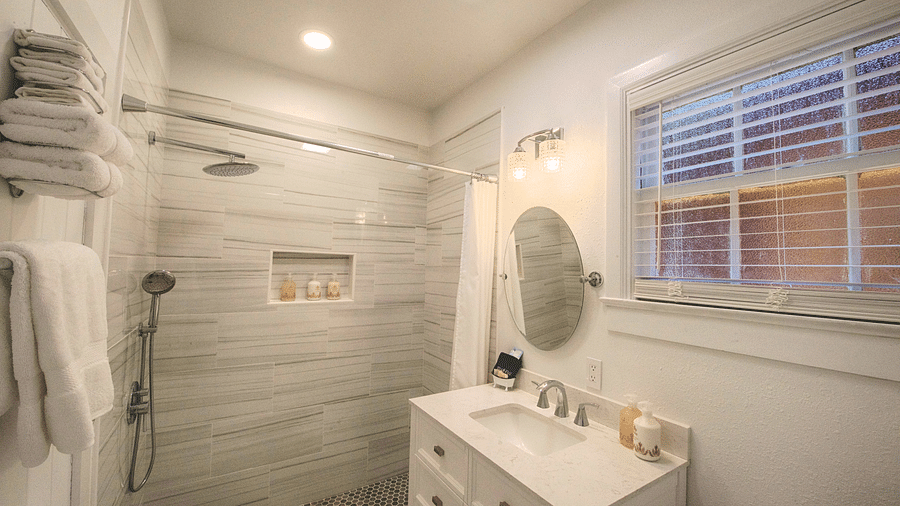 a bathroom with white and grey interiors with a well kept vanity area along with a huge window in front of it - Historic Tapoco Lodge