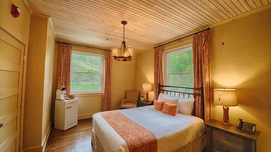 full view image of a bedroom with two huge windows with open curtains - Historic Tapoco Lodge