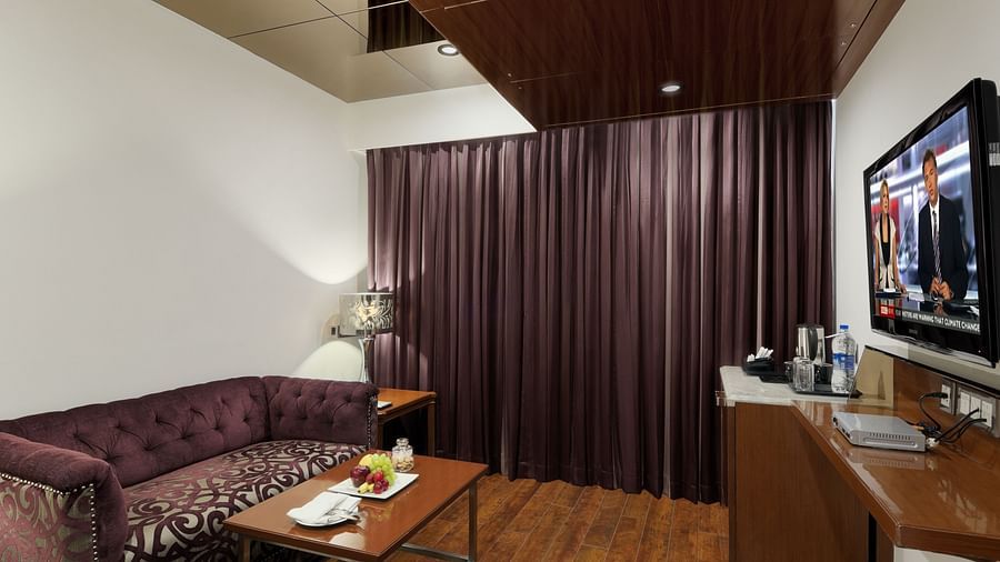 A room with a sitting area, television, and coffee setup at The Elanza Hotel.