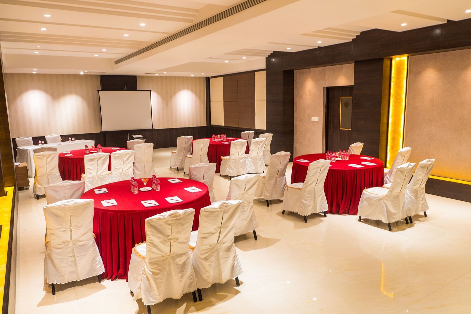 event hall with red tables and white satin chairs of ASR Parklane, Hosur