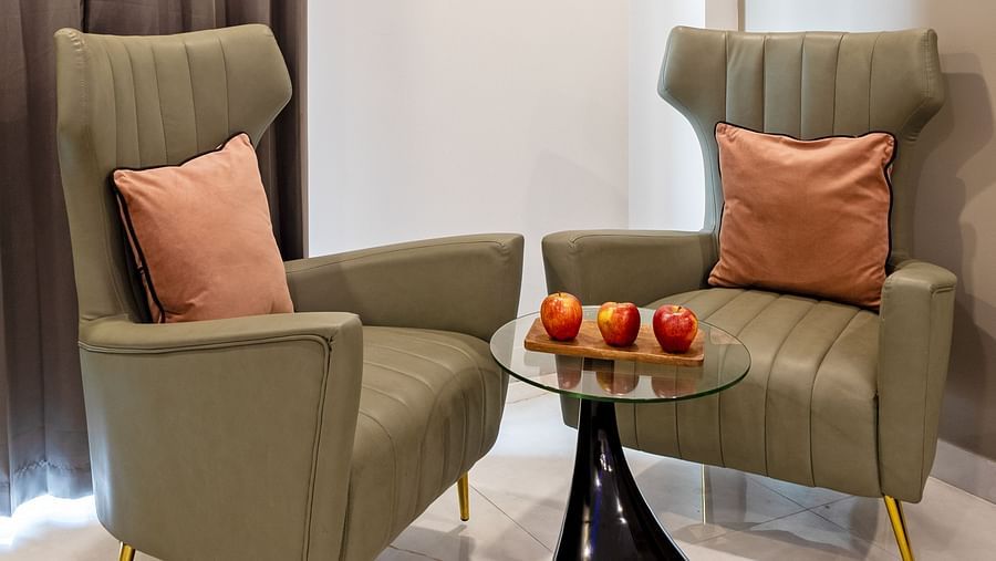Comfortable seating area with two plush chairs and a glass table at Hotel Bawa, Gurgaon.