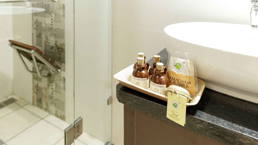 A modern bathroom with a glass-enclosed shower, a white sink, and wooden countertop.