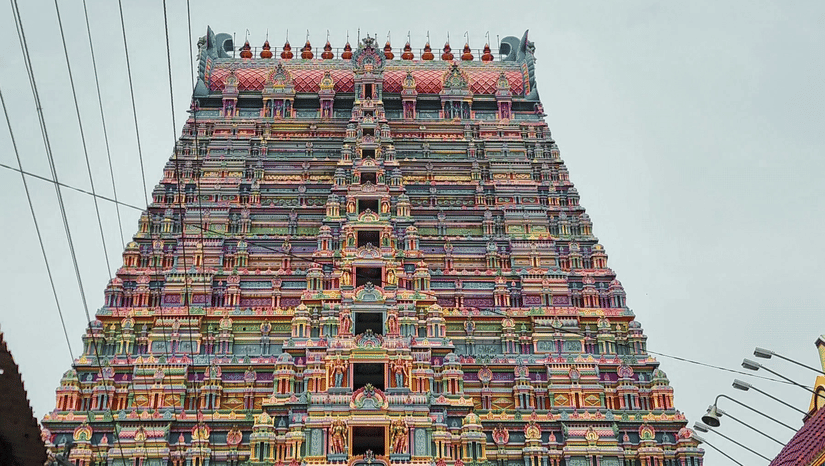 A majestic temple gopuram towers upwards, adorned with colourful sculptures and flanked by power lines, it is one of the famous temple in Pollachi.