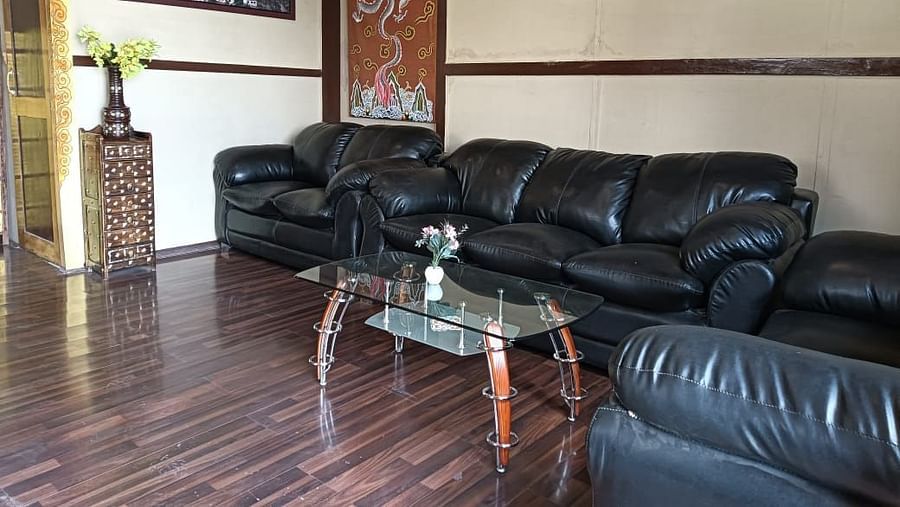Interior of White Sand Resort, Ladakh showcasing a seating area with leather sofas, a coffee table, and wall decorations.