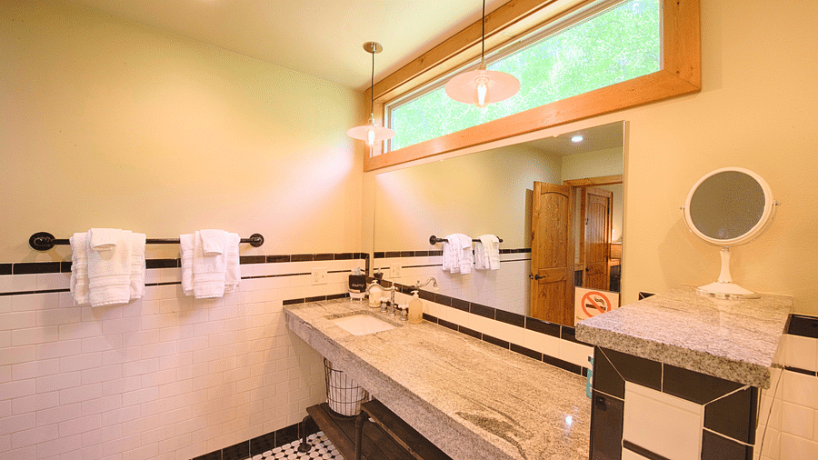 corner of a bathroom featuring a wide washbasin along with a mirror above it and fresh hand towels besides it - Historic Tapoco Lodge