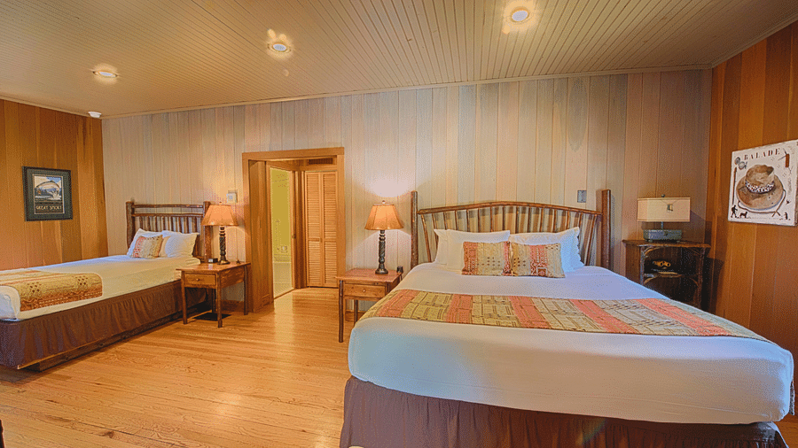 front view image of a double bed in a bedroom with two bed side tables on the either side of it - Historic Tapoco Lodge
