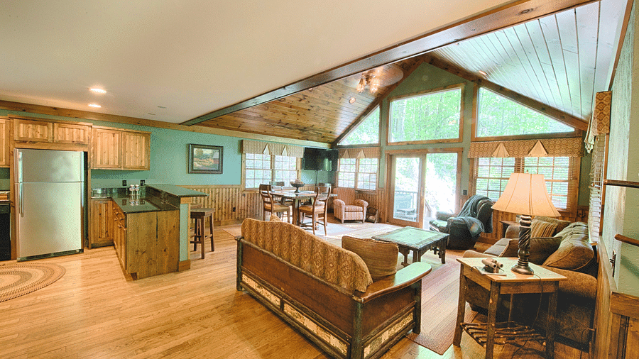 an entrance to the cabin featuring the entire living area along with a silver fridge in the corner - Historic Tapoco Lodge