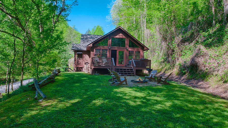 facade image of wooden cabin with a lush green lawn in front of it - Historic Tapoco Lodge