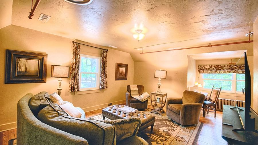 a luxurious living area with ample natural lighting in the room featuring a beautiful carpet under the couch - Historic Tapoco Lodge