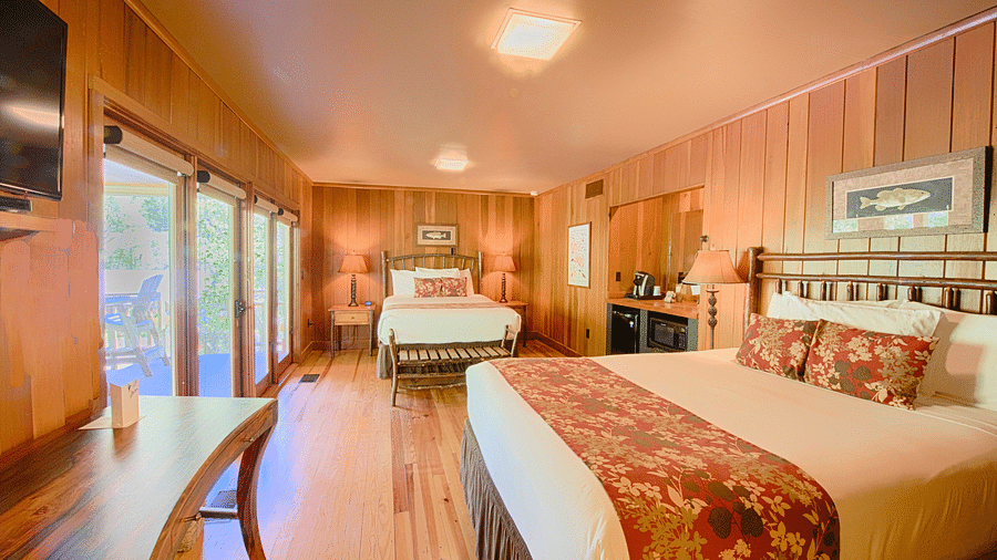 a room with ample of natural light coming from the huge windows featuring two comfortable double beds - Historic Tapoco Lodge