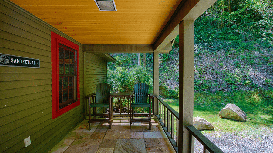 exterior of the cabin named Santeetlah Four with a spacious porch overlooking the empty space in front of it - Historic Tapoco Lodge