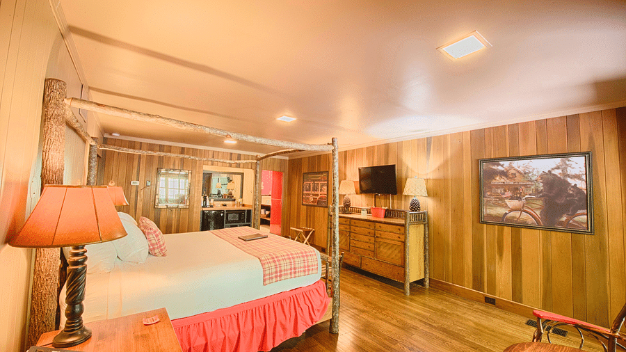 a cozy room with wooden interiors and modern amenities featuring a plush king size bed - Historic Tapoco Lodge