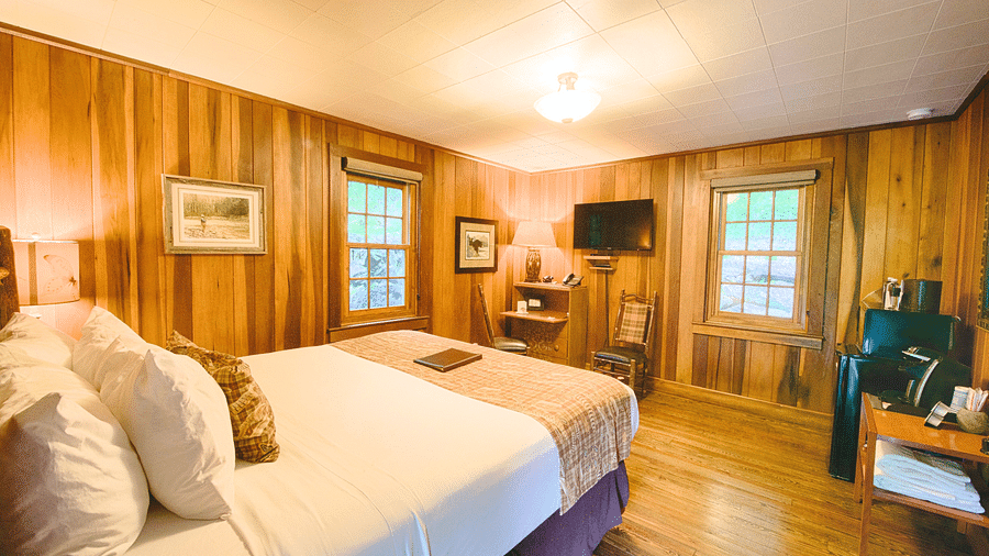 cornevr view image of the room overlooking a soft double bed facing the wall mounted television - Historic Tapoco Lodge