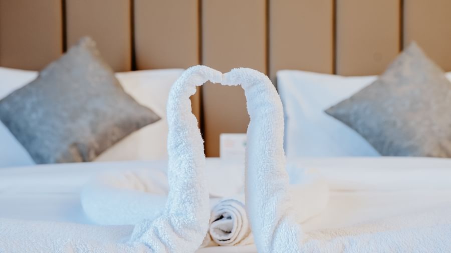 Close-up shot of the 2 towel swans placed on the double bed at the Bliss Room at Daksh The Grand Goverdhan, Dwarka.