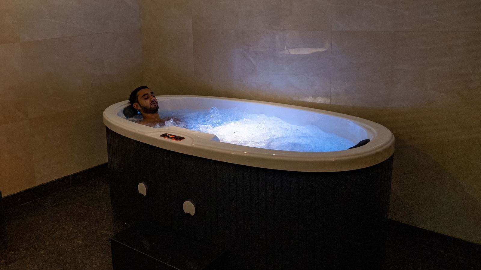 A person sitting inside a Jacuzzi inside the Presidential Villa - Gamyam Retreat