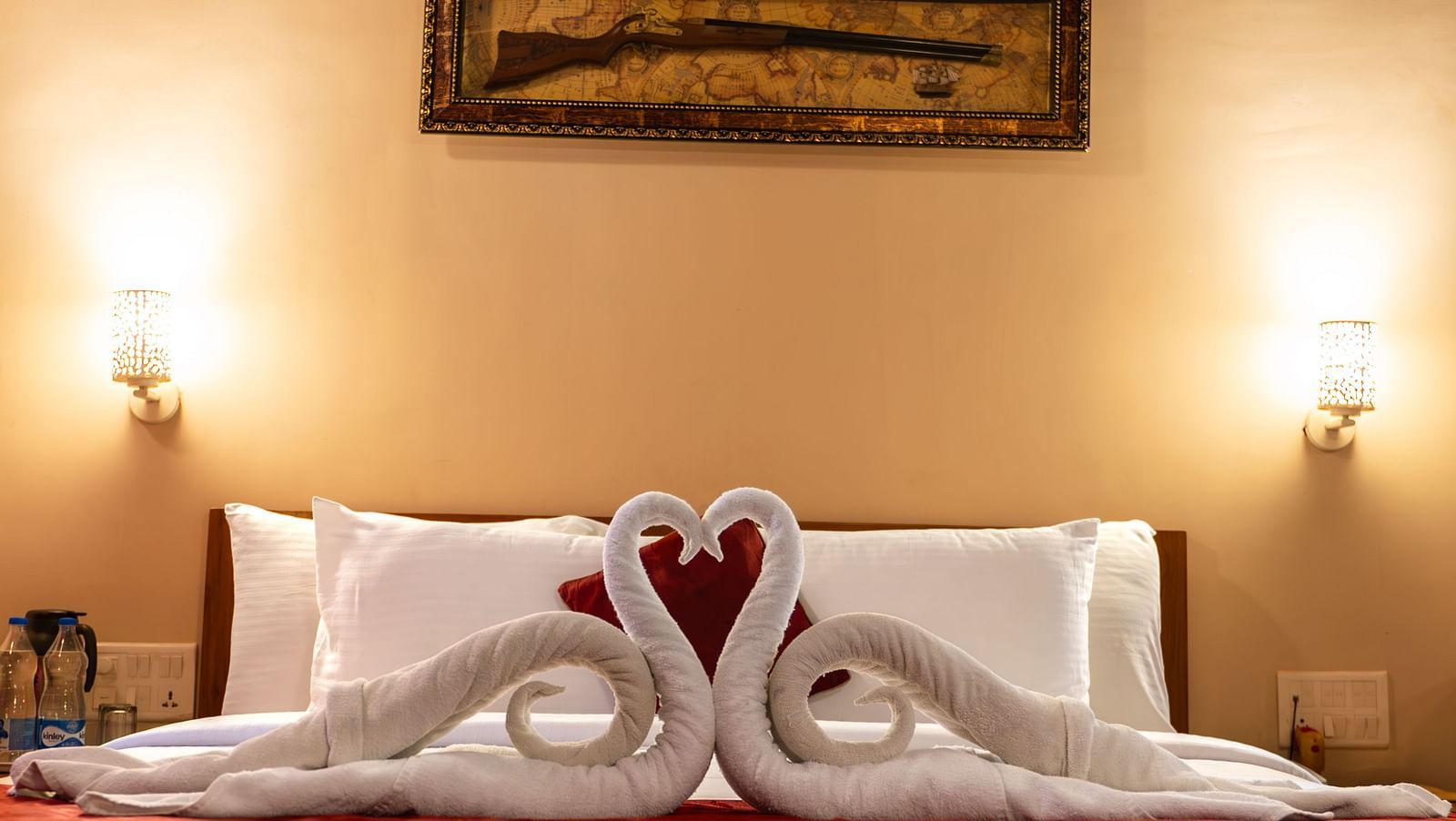 A close-up of bed of Attic Villa displays decorative towel swans | Woodstock Resorts, Coorg