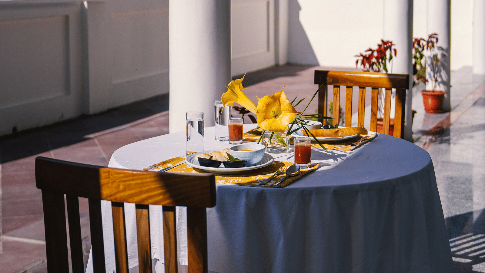 A table for two, neatly set for dining on the balcony at BluSalzz Villas - The Green Roof, Bhimtal.