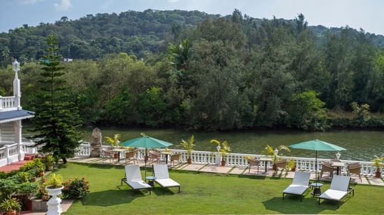 The Riverview outdoor seating arrangement amidst lush green scenery - Stone Wood Riverfront Resort, Siolim