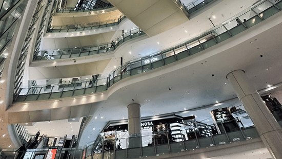 Multi-level interior of a large shopping mall with glass railings