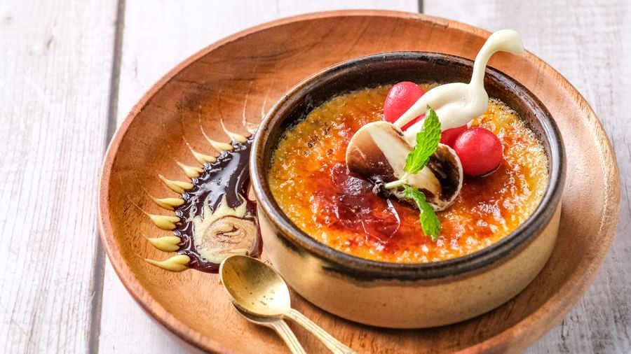 Traditional clay pot with spicy vegetarian stew on a rustic wooden table | Mango Hill, Pondicherry