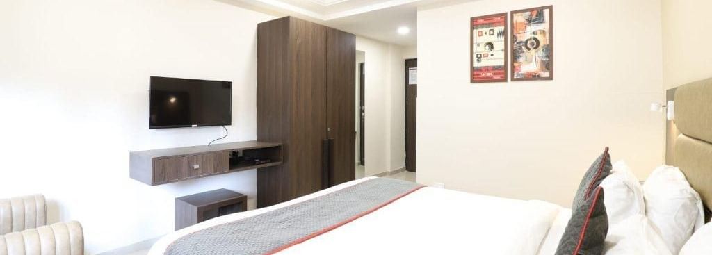 Corner view shot of the Premium Room featuring a double bed with a grey bed runner spread over it at Pravasa Ahmedabad.