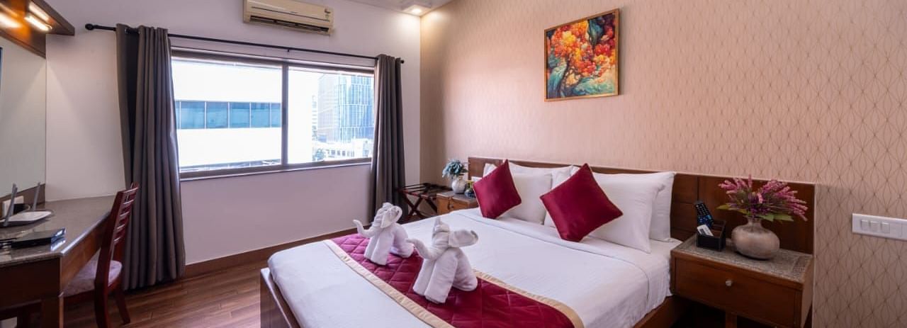 A cosy living room with comfortable sofas and wooden furniture offers a relaxing space at Lords Midtown Suites.