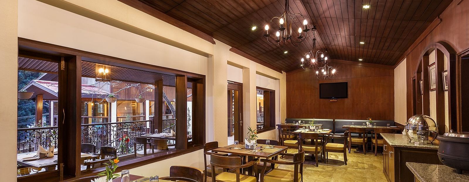 an indoor dining setup with tables lined up on one side and a buffet setup on the other side - The Earl's Court, Nainital