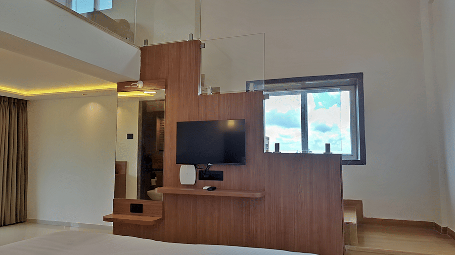 Bedroom with a double bed, television, wooden furnishings, and loft area.