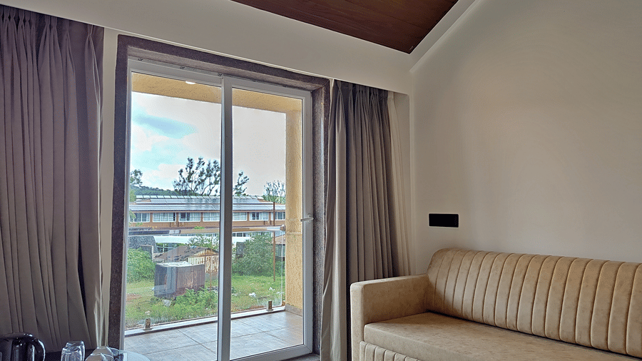 Room with a cushioned sofa, glass balcony doors, and wooden ceiling.