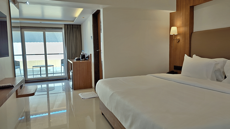 Bedroom with a double bed, wooden furnishings, bedside lights, and balcony access.