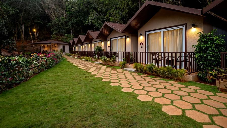 A well maintained corridor leading to the cottages illuminated by hanging lights - Stone Wood Nature Resort, Gokarna