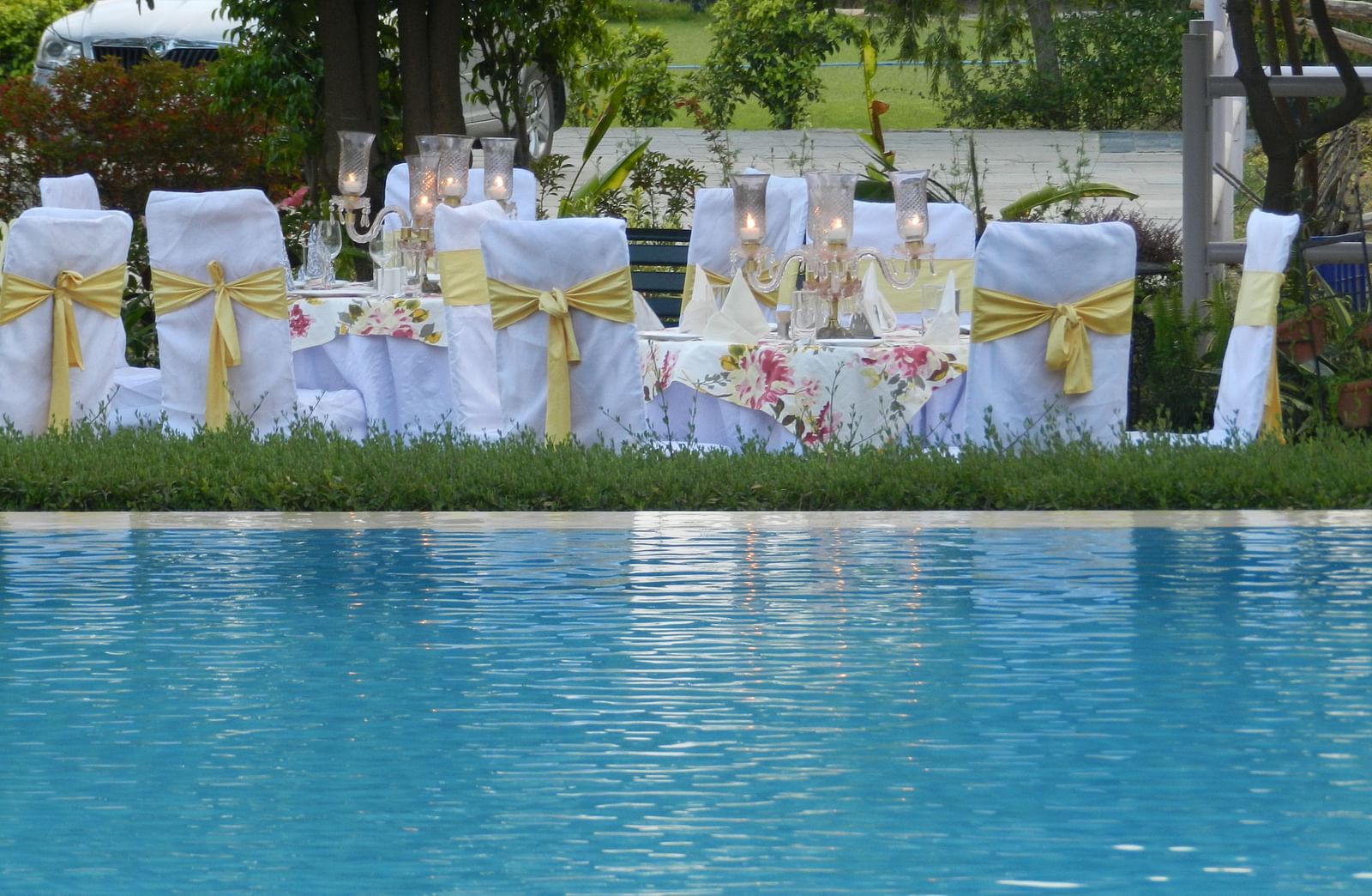 Elegant outdoor dining by the pool, with white and gold-decked tables set for a special event - Khas Bagh, Jaipur.