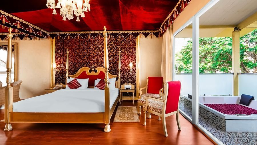 An overview of a room with a double bed, chairs and a bathtub outside - Rajasthali Resort & Spa, Jaipur.
