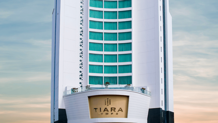 A daytime front view of a multi-storey Tiara by MPS, hotel tower against a bright blue sky.