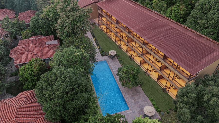 Aerial view of The Riverview Retreat, Corbett, featuring the swimming pool, resort buildings and surrounding forest.