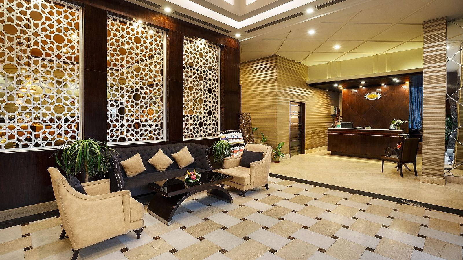 A sophisticated hotel lobby featuring a geometric patterned boards, plush seating, and a reception desk - The Manor, Bareilly