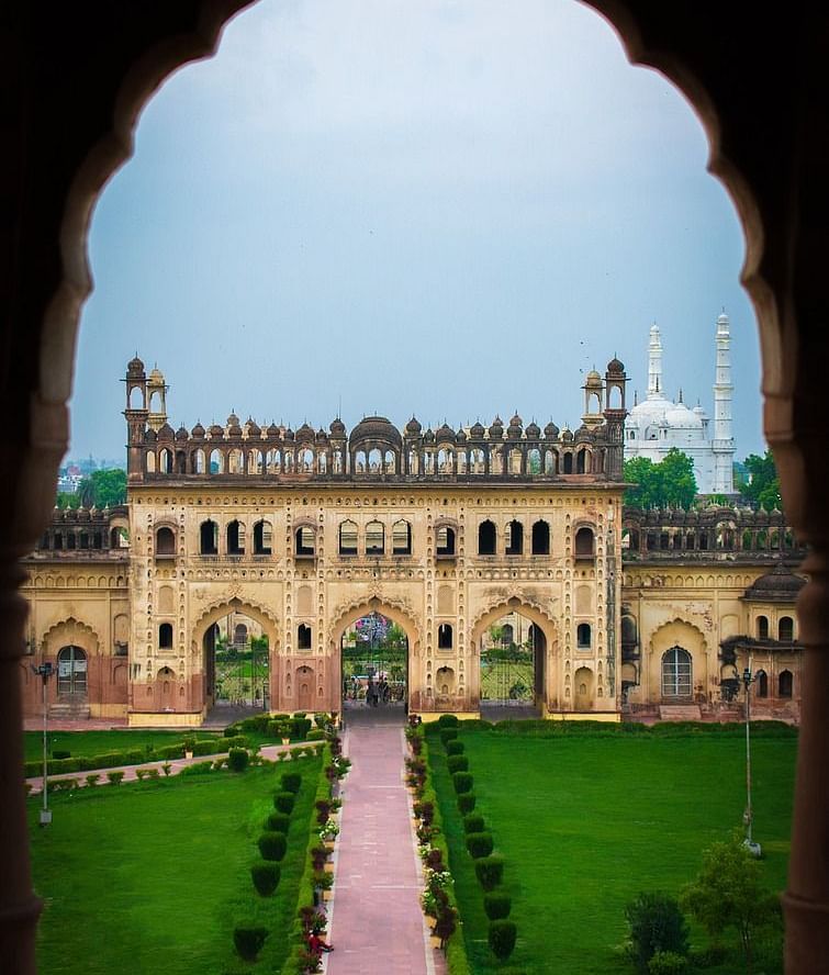Through an archway, a peaceful palace courtyard reveals lush gardens and beautiful architecture