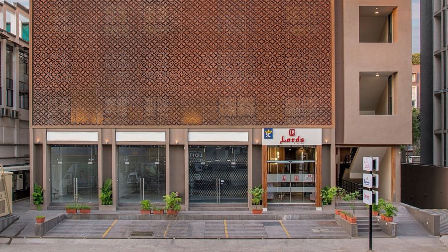 An exterior view of a modern, multi-storey hotel building in an urban setting - SK Lords Inn Ahmedabad