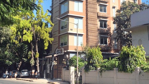 facade of theory9 service apartments in bandra during the day with trees in view.