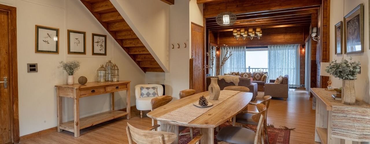 An image of dining space with table and chairs and stairs leading to the attic - Avalon Cottages, Kanatal