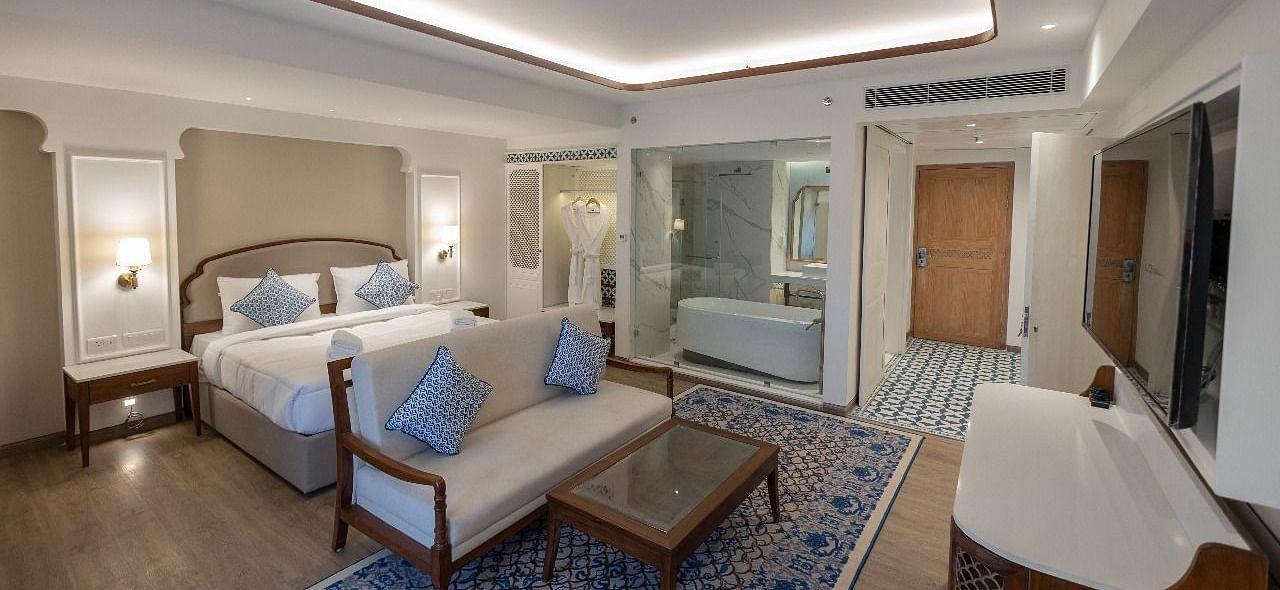 Full view shot of the Purna Room at Bhagirathi by RDB Atishay featuring a double bed and a couch in front of it at Bhagirathi by RDB Atishay. 