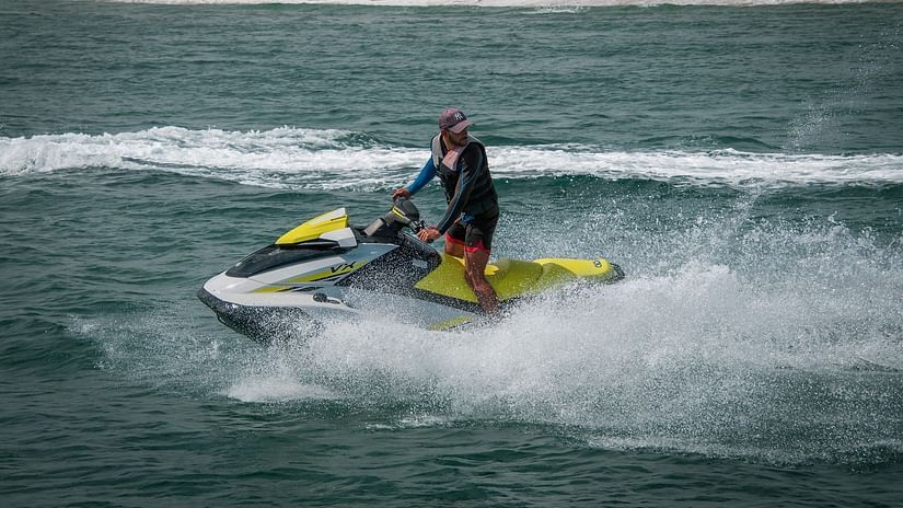 Person jet skiing and cutting through waters