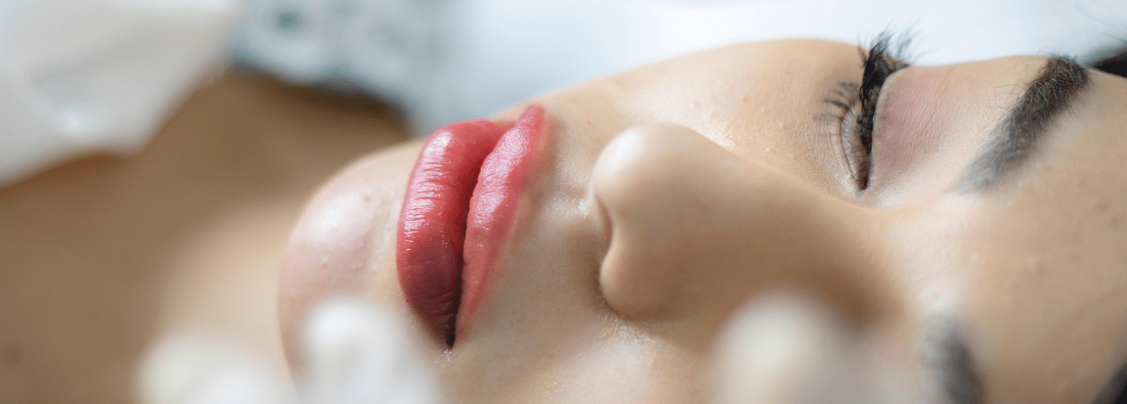 A woman lying down with her eyes closed, exuding a sense of peace and calm.